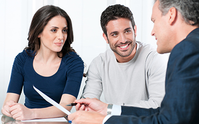 A man and a woman discussing buisness with another man