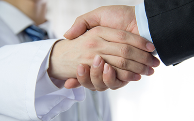 A doctor and business man shaking hands