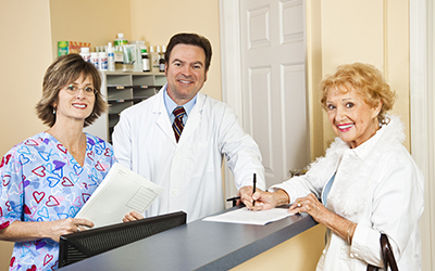 Doctor and front office staff greet a female patient