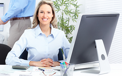 A woman sitting behind a computer smiling