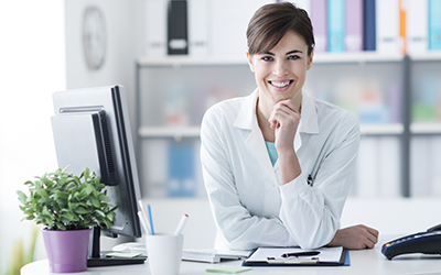 A business woman sitting at a desk smiling