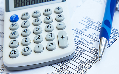 Financial reports with a pen and calculator sitting next to it